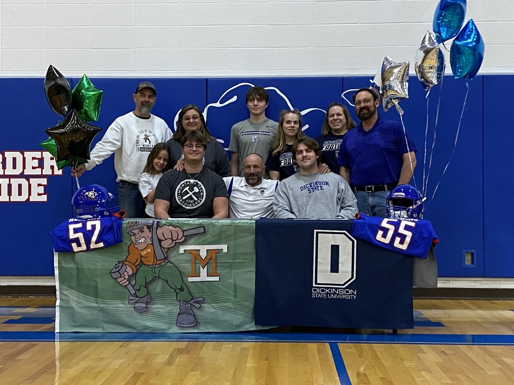 2 student-athletes and their families after signing letters of intent to play college football
