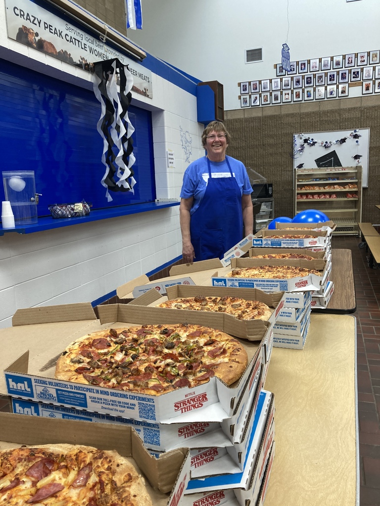 Cindy posing with pizza before her retirement party